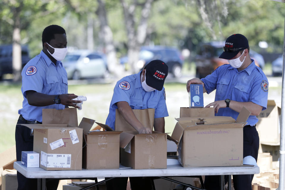 Members of Orange County Fire Rescue pack personal protective equipment (PPE) items including disposable face masks, reusable masks and hand sanitizer in bags to be handed out to small businesses, Wednesday, June 24, 2020, in Orlando, Fla. Because of the coronavirus pandemic, Orange County hopes to supply up to 10,000 businesses with the items over the next several days. (AP Photo/John Raoux)