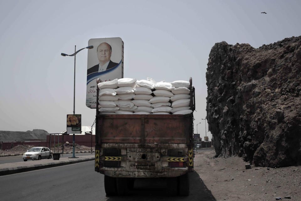 FILE - In this July 23, 2018 file photo, a truck carries aid on a road in Aden, Yemen. The U.N. says that a dozen humanitarian organizations in war-torn southern Yemen have suspended their work after a string of targeted attacks. Meanwhile, the country's rebel-led health ministry announced on Tuesday, Dec. 24, 2019, that severe outbreaks of swine flu and dengue fever have killed close to 200 people since October. (AP Photo/Nariman El-Mofty, File)