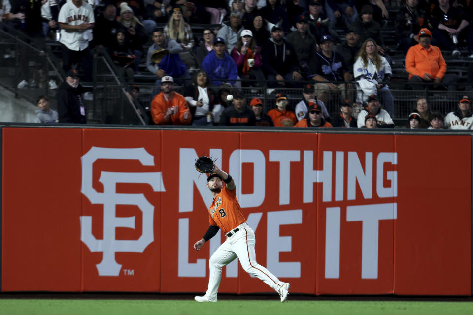 San Francisco Giants left fielder Michael Conforto (8) catches a ball hit by Los Angeles Dodgers' J.D. Martinez during the first inning of a baseball game in San Francisco, Friday, Sept. 29, 2023. (AP Photo/Jed Jacobsohn)