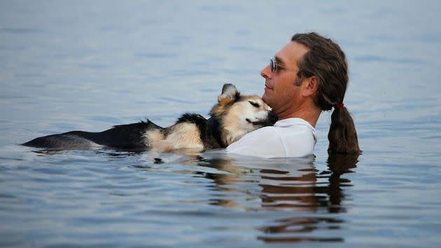 John Unger and his dog, Schoep, wade in Lake Superior. (Hannah Stonehouse Hudson/StonehousePhoto.com)