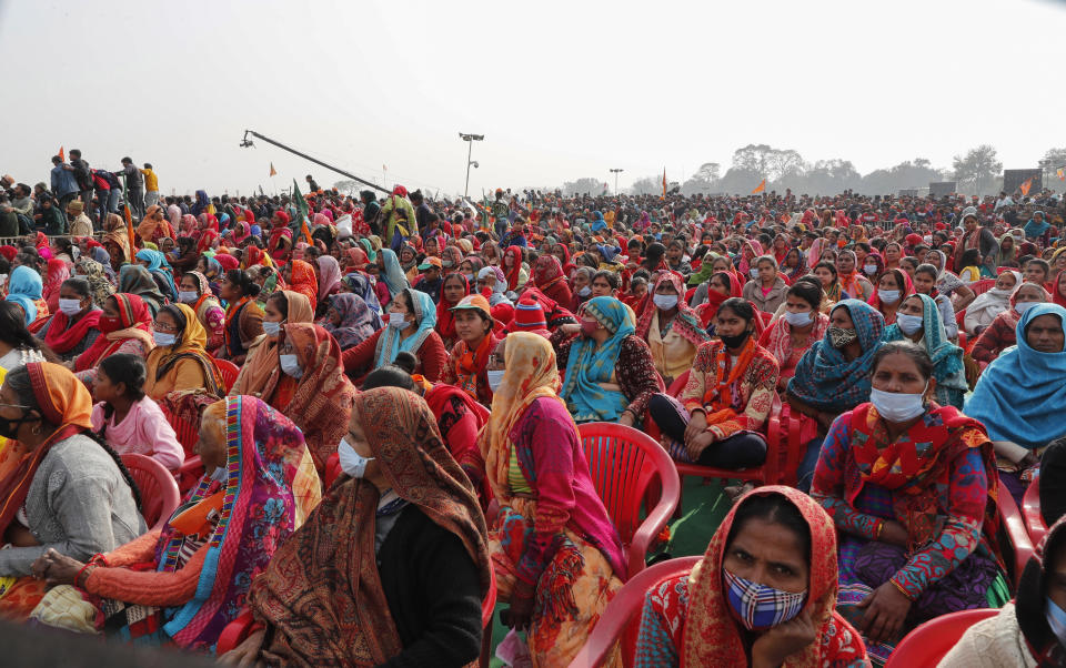 FILE - Women wearing face masks as a precaution against the coronavirus gather to listen to Indian Prime Minister Narendra Modi as he lays the foundation stone of Major Dhyan Chand Sports University in Meerut, Uttar Pradesh state on Jan. 2, 2022. Coronavirus cases fueled by the highly transmissible omicron variant have rocketed through India and the country is scrambling to ward off its impact by swiftly introducing a string of restrictions that the population thought were history. But India’s political leaders, including Modi, have largely flouted some of these guidelines and traversed cities in a massive campaign trail ahead of crucial state polls, addressing packed rallies of tens of thousands of people without masks. (AP Photo/Rajesh Kumar Singh, File)