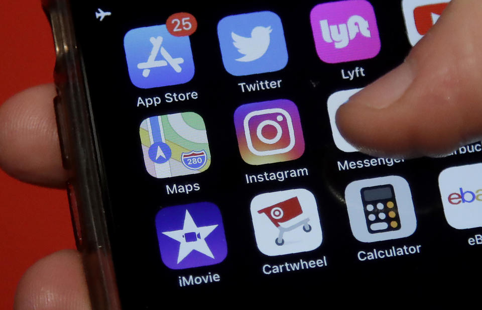 This July 10, 2019, photo shows an Associated Press reporter holding a phone showing the Instagram app icon in San Francisco. Instagram is expanding a test to hide how many “likes” people’s posts receive on its photo-sharing app as it tries to combat criticism that such counts hurt mental health and make people feel bad when comparing themselves to others. (AP Photo/Jeff Chiu)