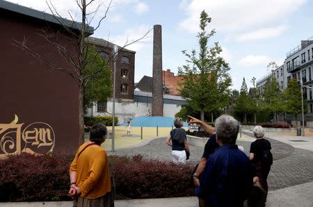 Tourists visit the Brussels district of Molenbeek during a guided tour showing off the area's manufacturing heritage, diverse population and lively market, Belgium, August 13, 2016. REUTERS/Francois Lenoir