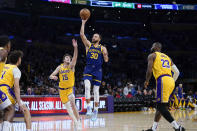 Golden State Warriors guard Stephen Curry (30) shoots against Los Angeles Lakers guard Austin Reaves (15) as forward LeBron James (23) watches during the first half of an NBA basketball game, Tuesday, April 9, 2024, in Los Angeles. (AP Photo/Ryan Sun)