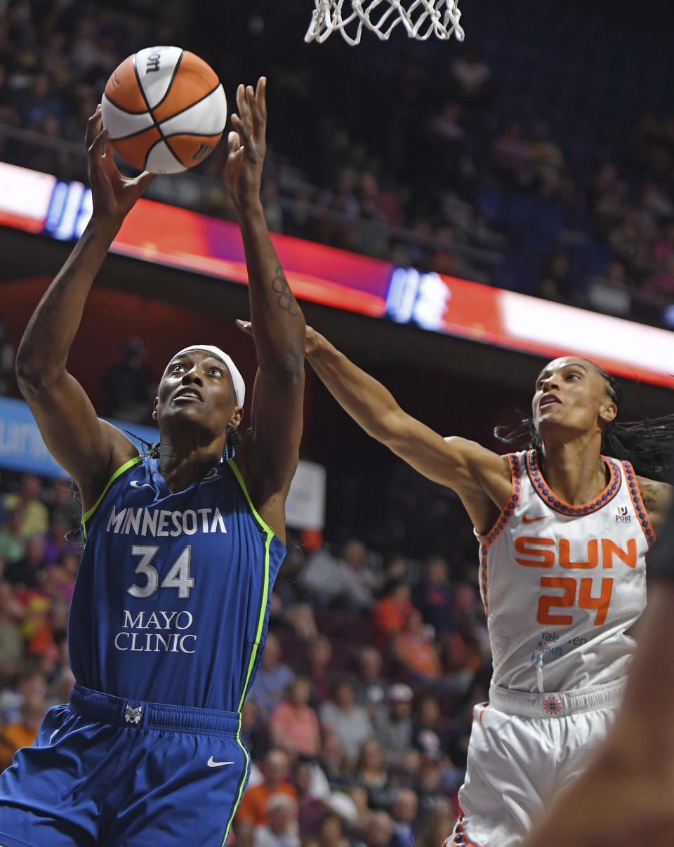 Minnesota Lynx center Sylvia Fowles (34) drives to the basket around Connecticut Sun forward DeWanna Bonner (24) during a WNBA basketball game Sunday, Aug. 14, 2022, in Uncasville, Conn. (Sean D. Elliot/The Day via AP)