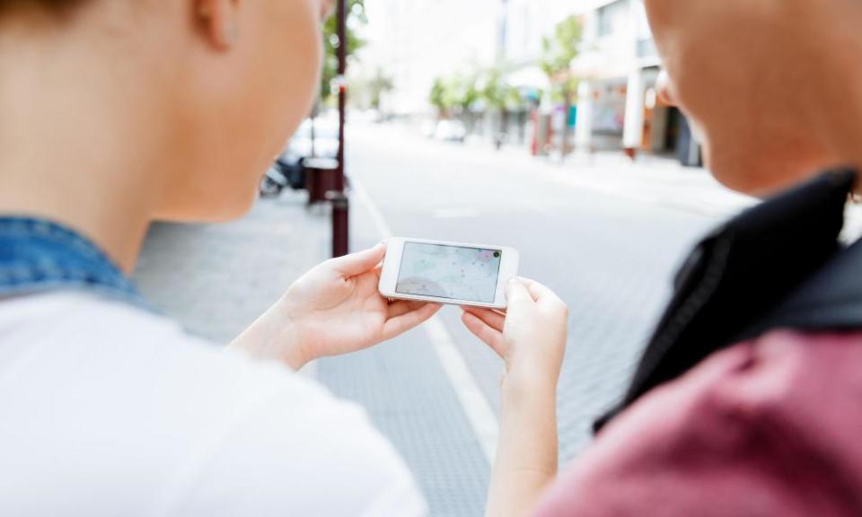 Tourists using navigation app on the mobile phone.