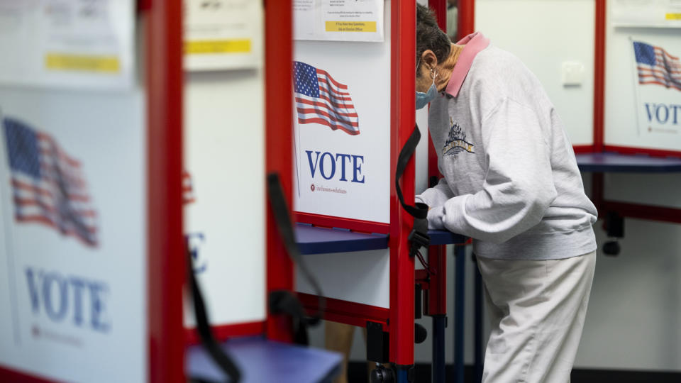 A voter fills out her ballot 