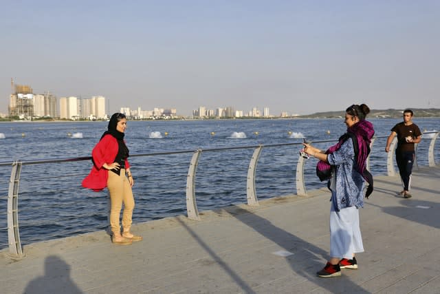 Women take a picture while spending an afternoon around the Persian Gulf Martyrs’ Lake in Tehran