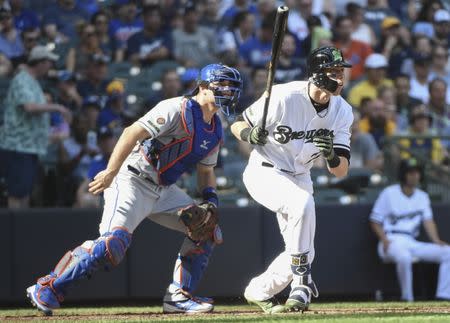 May 26, 2018; Milwaukee, WI, USA; Milwaukee Brewers right fielder Christian Yelich (22) hits a triple to drive in a run in the fourth inning as New York Mets catcher Devin Mesoraco (29) watches at Miller Park. Mandatory Credit: Benny Sieu-USA TODAY Sports