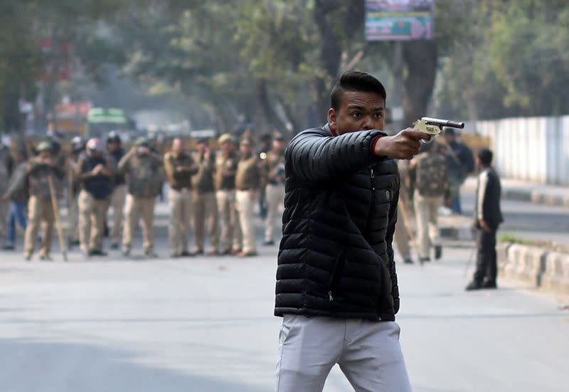 Man brandishes a gun during a protest against a new citizenship law outside the Jamia Millia Islamia university in New Delhi