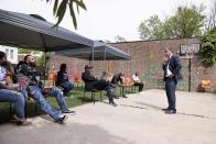 Philadelphia District Attorney candidate Carlos Vega, right, listens to a question from Nakisha Billa and Leroy Russell, far left, during a meet and greet event at Read Ready Daycare and Early Learning Academy in Philadelphia, on Sunday, May 16, 2021. Vega is challenging incumbent District Attorney Larry Krasner and both candidates are making a final push for votes before the election on May 18. (Elizabeth Robertson/The Philadelphia Inquirer via AP)