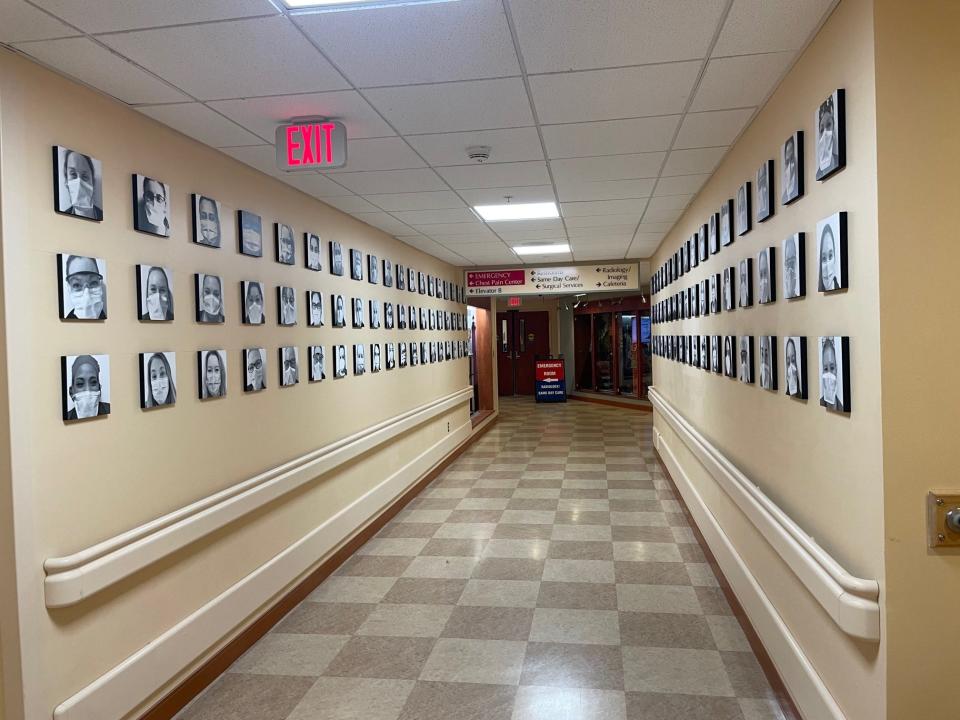 Photos of masked Portsmouth Regional Hospital employees line the hallway on the first floor of the hospital. The photo installation was designed to celebrate the contributions and commitment made by hospital staff every day to care for their patients, colleagues, and communities.