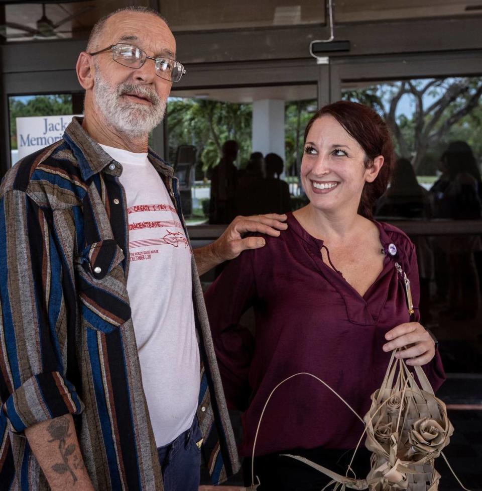 Dale Silvia, left, and social services director Sami Rudnick-Hoover, LCSW, pose for pictures after taking off their masks in front of Jackson Memorial Perdue Medical Center on June 21, 2021.