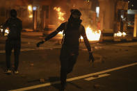 Pro-democracy protesters set fire to the toll gates to the Cross-Harbour Tunnel with molotov cocktails in Hong Kong, Thursday, Nov. 14, 2019. Hong Kong police warned protesters on Thursday that they were moving "one step closer to terrorism" by sinking the city into chaos, as riot squads skirmished with militant students at major universities. (AP Photo/Ng Han Guan)