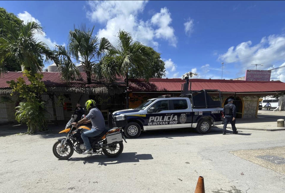 A police vehicle is parked outside the restaurant the day after a fatal shooting in Tulum, Mexico, Friday, Oct. 22, 2021. Two foreigners were killed and three wounded in a shooting in the Mexican Caribbean resort town of Tulum. (AP Photo/Christian Rojas)