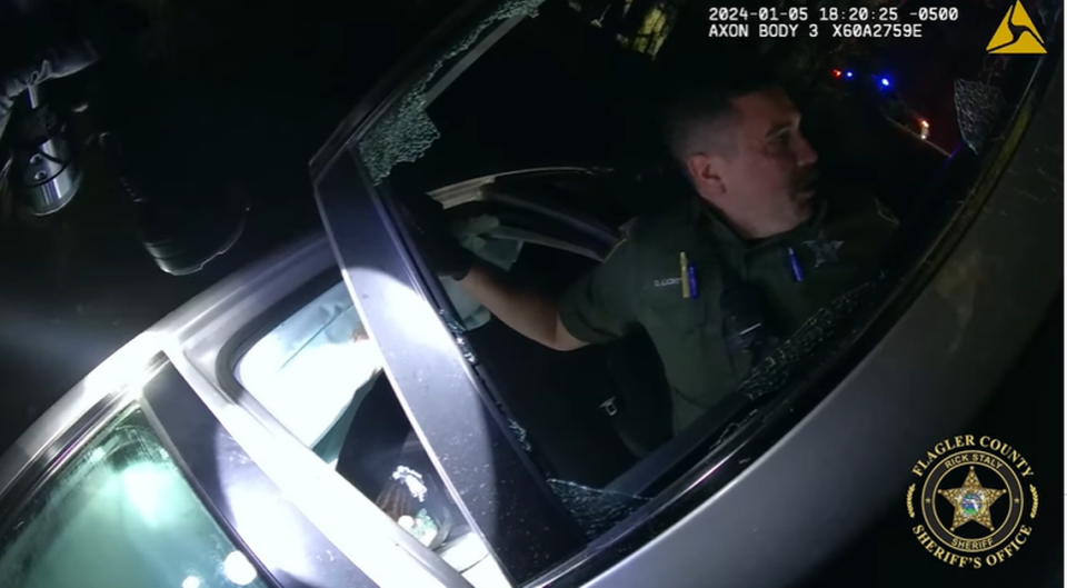 A small child and an adult woman were trapped inside the vehicle, and deputies had to bust the window to get inside, the video showed.