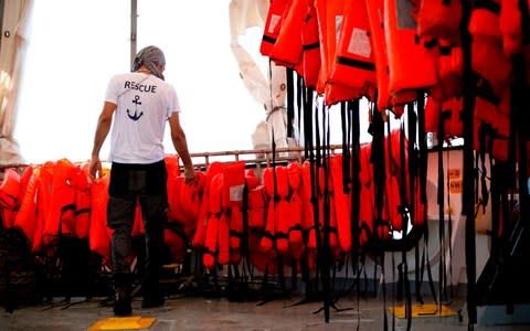 A member of SOS-Mediterranee checks life vests aboard the Aquarius rescue vessel - Credit: PAU BARRENA/AFP/Getty Images