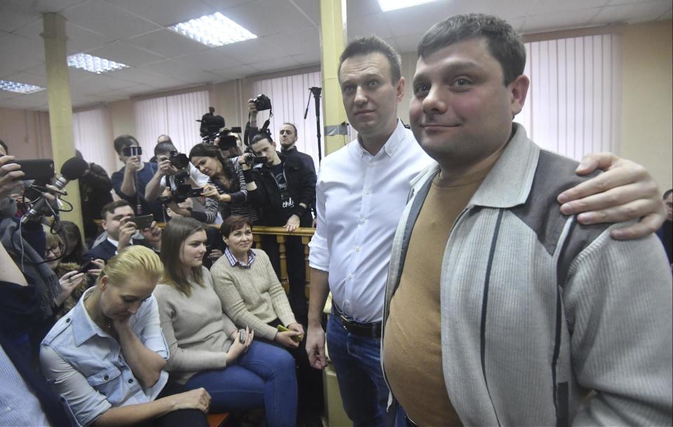 Russian opposition leader Alexei Navalny, second right, poses with his former colleague Pyotr Ofitserov, right, in the court in Kirov, Russia, Wednesday, Feb. 8, 2017. Alexei Navalny's wife Yulia is on the left. A Russian court on Wednesday found opposition leader Alexei Navalny guilty in the retrial of a 2013 fraud case, which disqualifies him as a candidate for president next year. However, an associate said Navalny will carry on with the campaign he announced in December. (AP Photo/Sergei Bonurin)