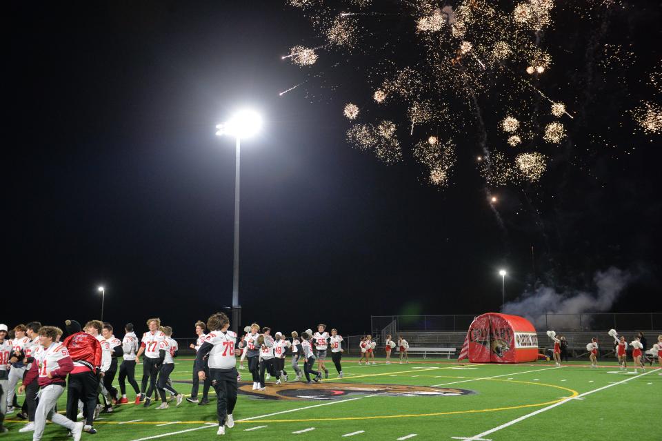 Fireworks burst overhead as the Cardinal Mooney football team runs onto John Heath Field at Austin Smithers Stadium during a celebration of the Cougars' winning the 2023 Class 1S state title.
(Credit: Mike Lang)