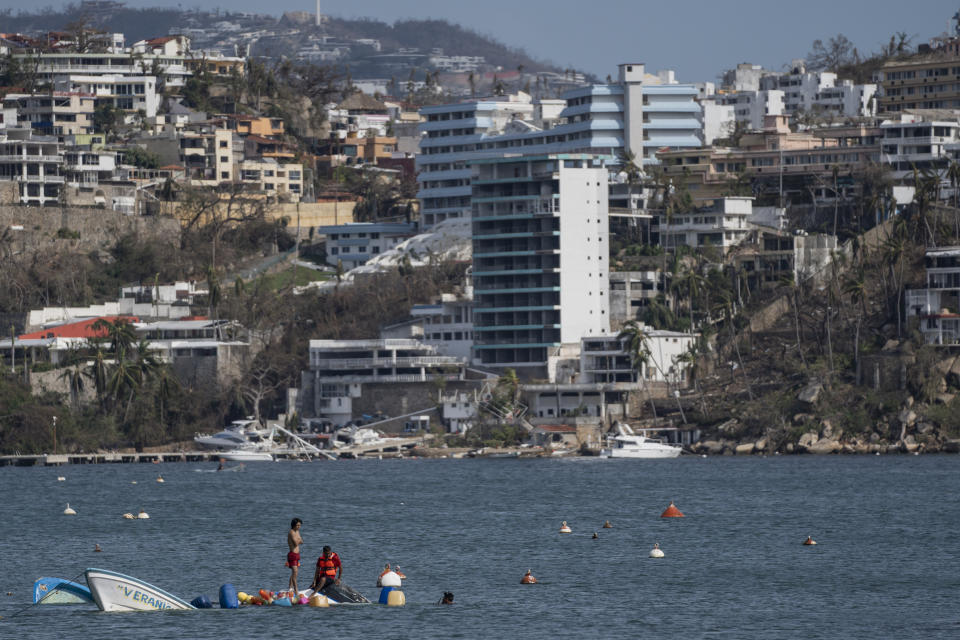 Fishermen try to rescue sunken boats in the aftermath of Hurricane Otis in Acapulco, Mexico, Saturday, Oct. 28, 2023. (AP Photo/Felix Marquez)