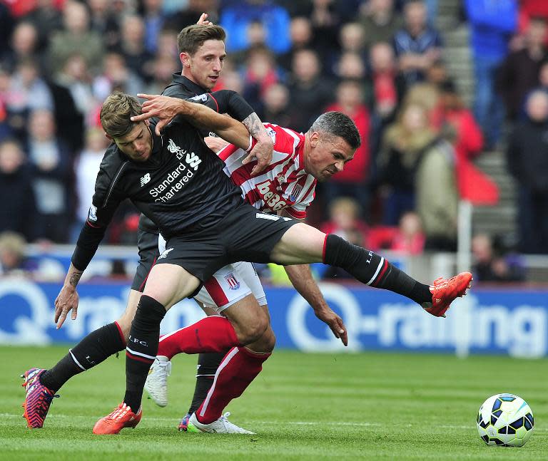Liverpool's Alberto Moreno (L) fights to keep the ball away from Stoke City's Jonathan Walters during the match at the Britannia Stadium in Stoke-on-Trent, on May 24, 2015