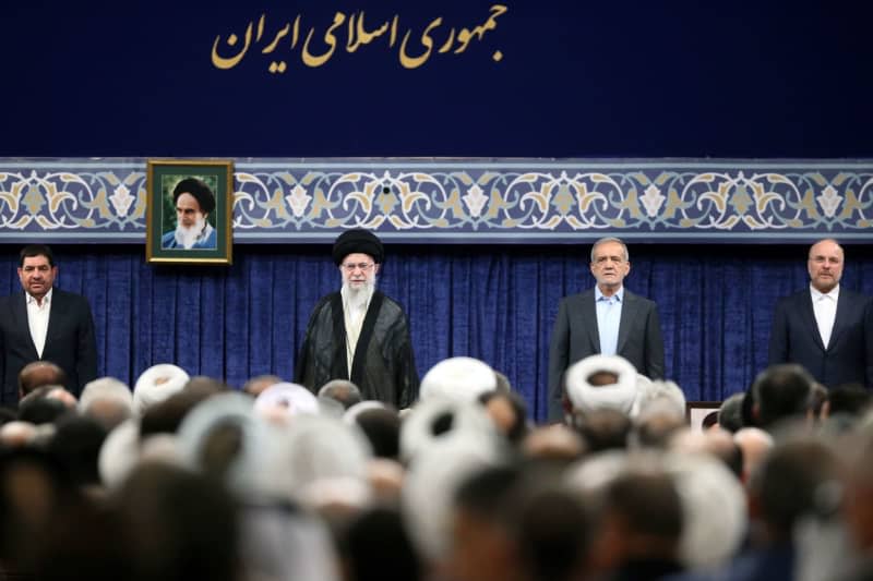 Iranian Supreme Leader Ayatollah Ali Khamenei (CL) and newly elected President Masoud Pezeshkian (CR) attend the ceremony in support of the new president in Tehran. -/Iranian Presidency/dpa