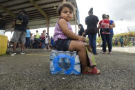 <p>Kerialys Aldea de Jesus sits on bottled water at the Jose de Diego Elementary School where residents file FEMA forms for federal aid in the aftermath of Hurricane Maria in Las Piedras, Puerto Rico, Monday, Oct. 2, 2017. Even those happy with the federal aid effort for the U.S. territory’s 3.4 million people said they resented President Donald Trump’s tweets about some Puerto Ricans being lazy and ungrateful. (Photo: Carlos Giusti/AP) </p>