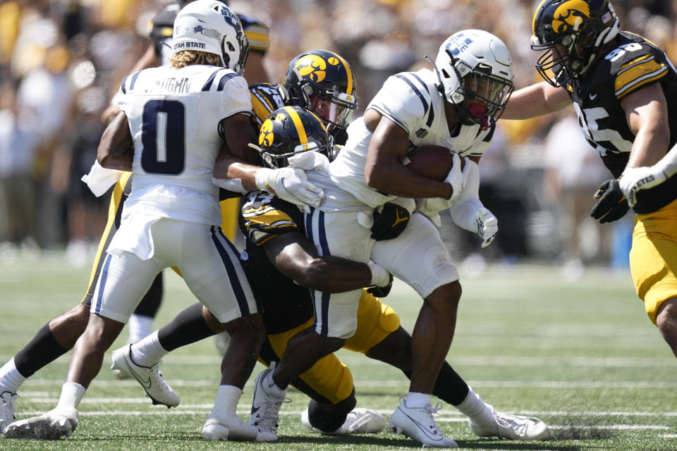 Utah State wide receiver Micah Davis (4) is tackled by Iowa linebacker Jay Higgins (34) during the first half of an NCAA college football game, Saturday, Sept. 2, 2023, in Iowa City, Iowa. (AP Photo/Charlie Neibergall)