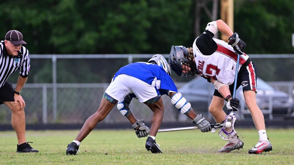Palm Beach Central's Logan Birdsall and Wellington's Michaeuxn Jackson dig deep during a faceoff during a game on April 3, 2024.
