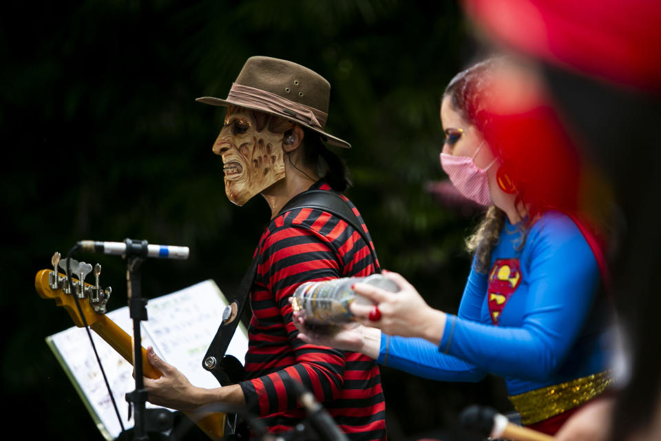 Musicians perform in the "Desliga da Justica" street band in Rio de Janeiro, Brazil, Sunday, Feb. 14, 2021. Their performance was broadcast live on social media for those who were unable to participate in the carnival due to COVID restrictions after the city's government officially suspended Carnival and banned street parades or clandestine parties. (AP Photo/Bruna Prado)