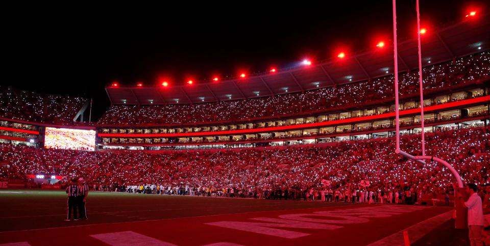 Fans use their cellphone lights as the stadium lights shine red during a timeout on Sept. 25, 2021, at Bryant-Denny Stadium in a game against Southern Miss.