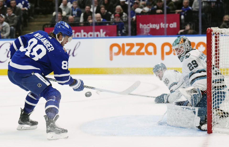Toronto Maple Leafs forward William Nylander (88) tries to knock the puck out of the air as San Jose Sharks goaltender Mackenzie Blackwood (29) looks on during the second period of an NHL hockey game, Tuesday, Jan. 9, 2024 in Toronto. (Nathan Denette/The Canadian Press via AP)