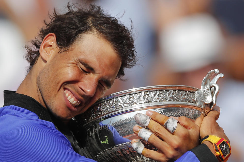 FILE - In this June 11, 2017, file photo, Spain's Rafael Nadal holds the trophy as he celebrates winning his tenth French Open title, against Switzerland's Stan Wawrinka, at Roland Garros stadium, in Paris, France. Federer leads the list with 20 Grand Slam singles titles. Nadal has 19. Novak Djokovic has 16. (AP Photo/Christophe Ena, File)