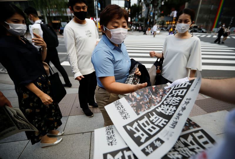 A person receives extra edition of a newspaper reporting former Japanese Foreign Minister Fumio Kishida won in a ruling party leadership election, in Tokyo