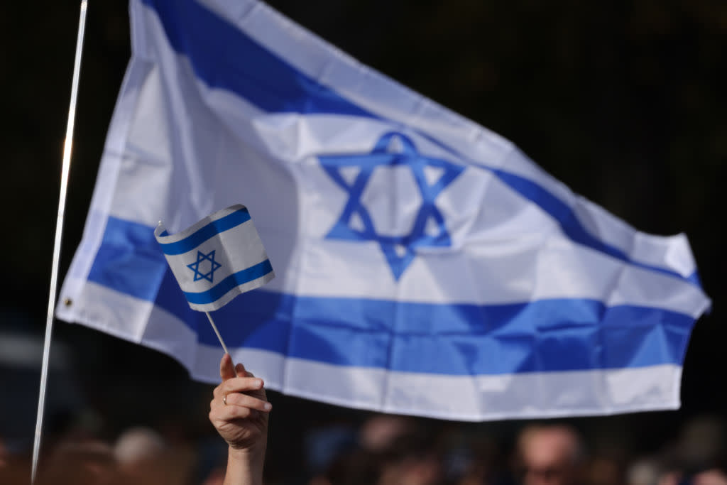  People gather under Israeli flags at a demonstration to show solidarity with Israel and against anti-semitism. 