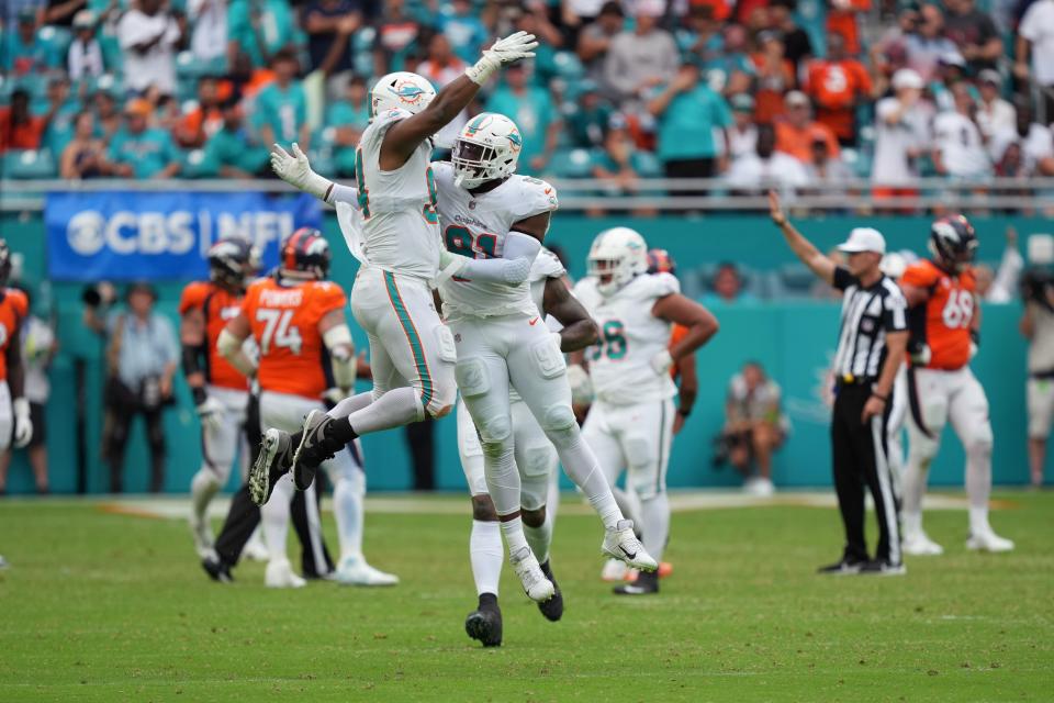 Miami Dolphins defensive end Emmanuel Ogbah (91) celebrates a sack of Denver Broncos quarterback Russell Wilson with defensive tackle Christian Wilkins (94) during the second half of an NFL game at Hard Rock Stadium in Miami Gardens, Sept. 24, 2023.