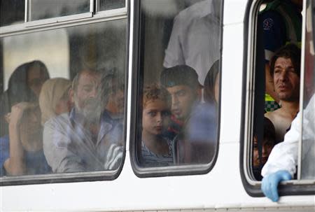 REFILE - CORRECTING NAME OF HARBOUR Rescued migrants sit in a police bus after arriving at the Armed Forces of Malta Maritime Squadron base at Haywharf in Valletta's Marsamxett Harbour October 12, 2013. REUTERS/Darrin Zammit Lupi