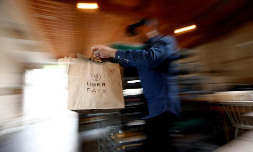 FILE PHOTO: A bag of donuts destined for delivery via Uber Eats is rushed to a driver from a kitchen in Sydney August 12, 2016. REUTERS/Jason Reed/File Photo