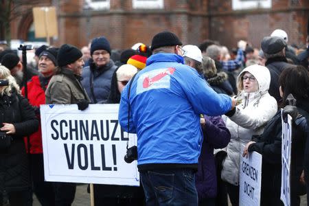 People attend a demonstration against migrants in Cottbus, Germany February 3, 2018. Sign reads "Fed up!". REUTERS/Hannibal Hanschke