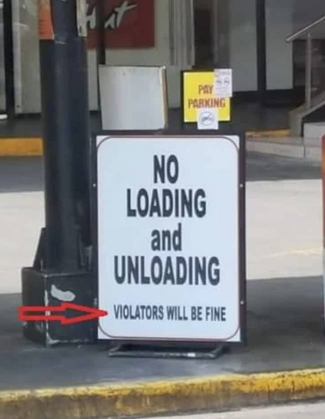 Sign at a parking area states, "NO LOADING and UNLOADING. VIOLATORS WILL BE FINE." A red arrow points to a small joke on the sign's base