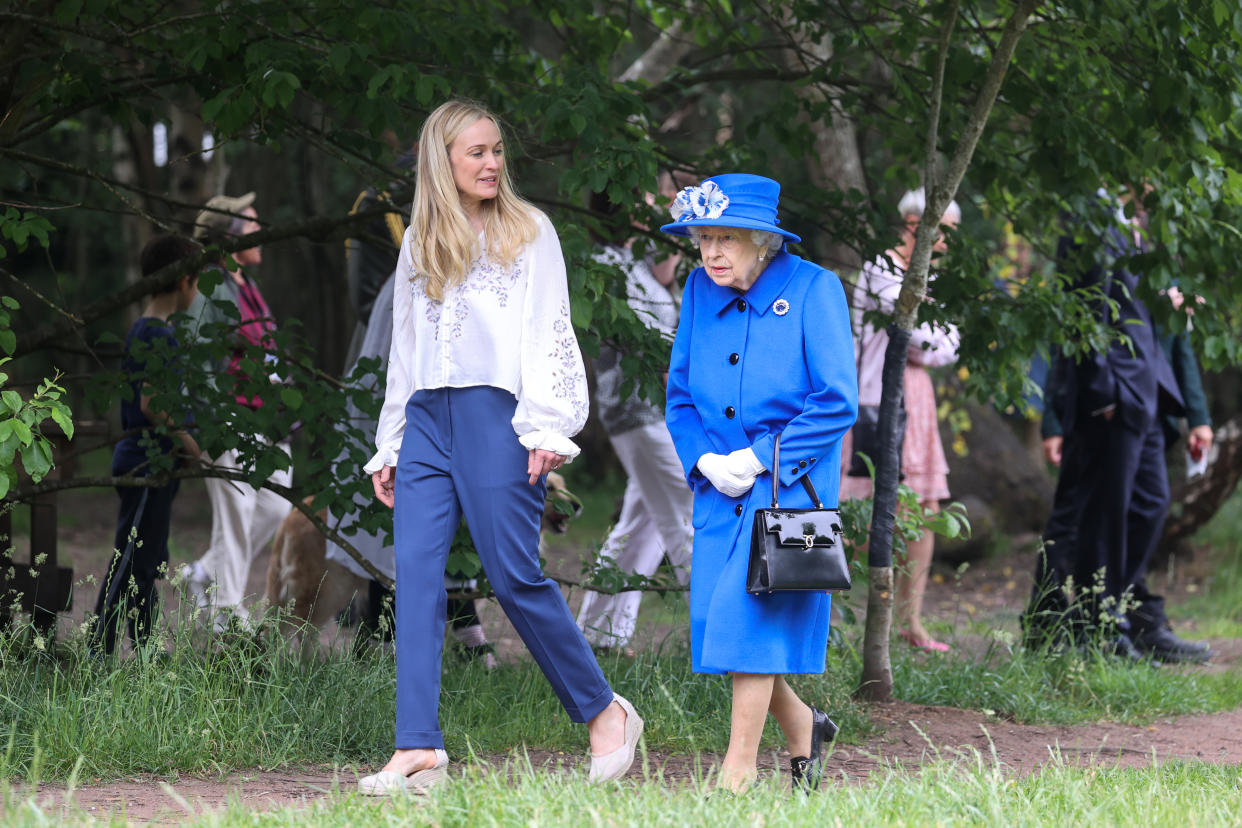 GLASGOW, SCOTLAND - JUNE 30: Queen Elizabeth II has a tour of the grounds with Director of The Children’s Wood Project, Emily Cutts  during a visit to the Children's Wood Project on June 30, 2021 in Glasgow, Scotland. The Children’s Wood Project is a dedicated green space designed to connect local people with nature, raise aspirations and bring the community together through outdoor activities such as gardening, beekeeping and forest schools. The Queen is visiting Scotland for Royal Week between Monday 28th June and Thursday 1st July 2021. (Photo by Chris Jackson/Getty Images)