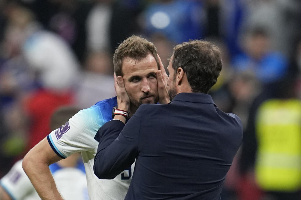 El delantero inglés Harry Kane es consolado por el técnico Gareth Southgate tras la derrota 2-1 ante Francia en los cuartos de final del Mundial, el sábado 10 de diciembre de 2022, en el estadio Al Bayt en Jor, Qatar. (AP Foto/Abbie Parr)