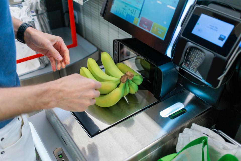 una persona comprando plátanos 
