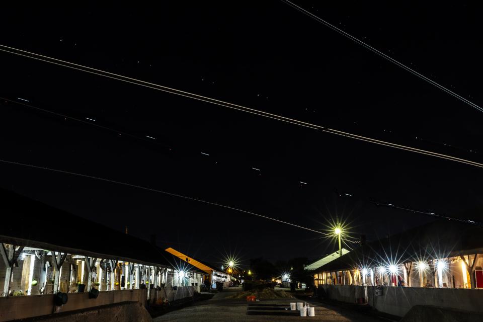 Trails of light from UPS jets leaving Muhammad Ali International Airport appear over the stables at Churchill Downs in this multiple exposure photo. Special to the Courier Journal by Pat McDonogh. April 20, 2024