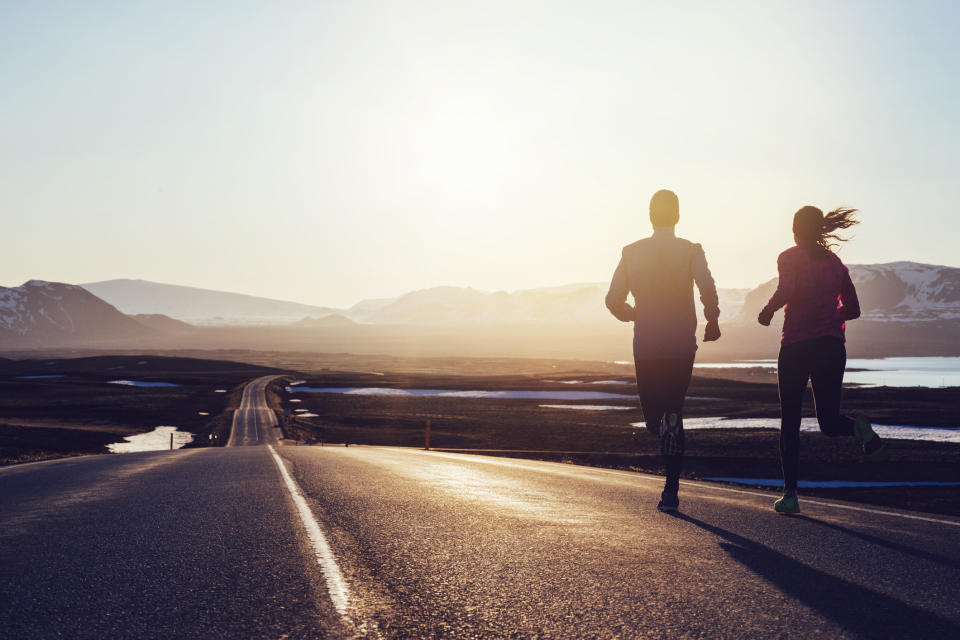 Two runners jogging together into the distance.