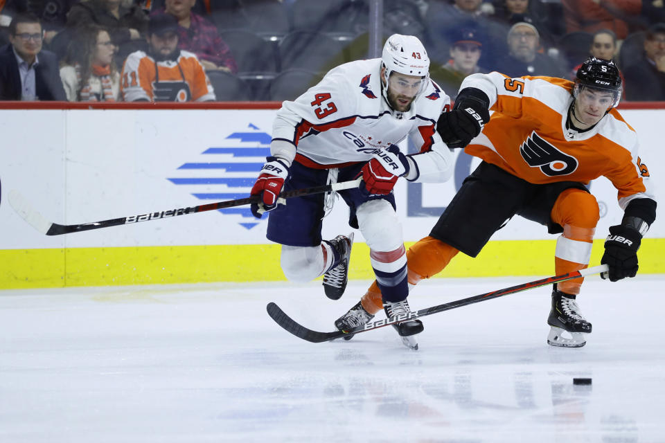 Philadelphia Flyers' Philippe Myers (5) and Washington Capitals' Tom Wilson (43) chase the puck during the second period of an NHL hockey game Wednesday, Jan. 8, 2020, in Philadelphia. (AP Photo/Matt Slocum)