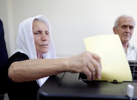 A woman casts her ballot at a polling station near Tirana