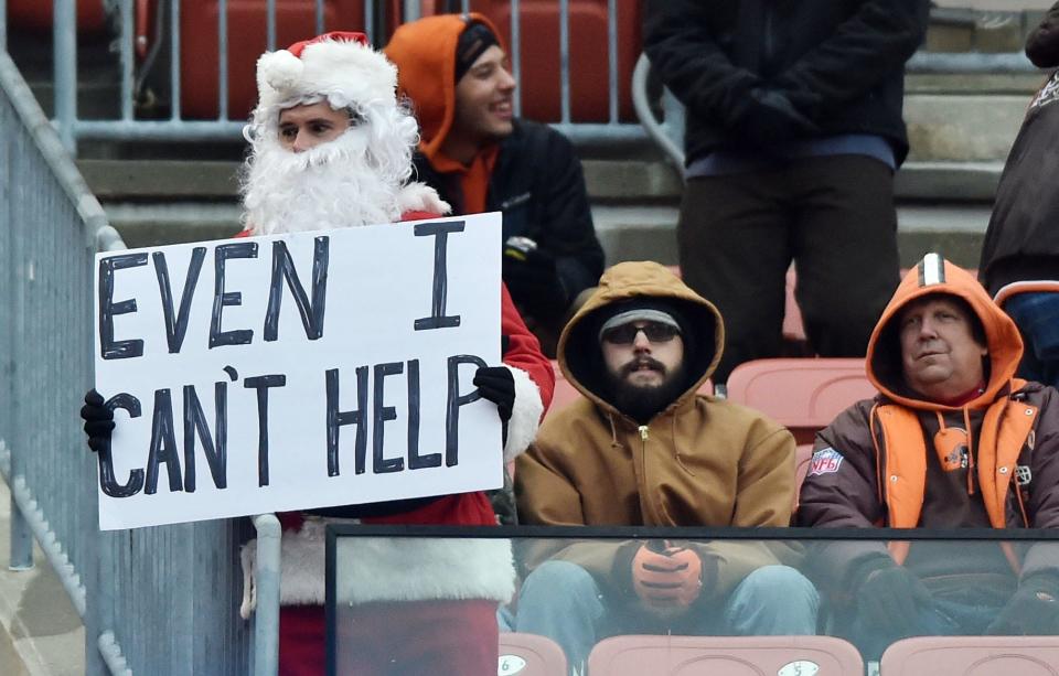 A Cleveland Browns fan dressed as Santa Claus holds a sign during the game between the Cleveland Browns and the Baltimore Ravens at Cleveland Browns Stadium in 2017. (Credit: Ken Blaze, USA TODAY Sports)