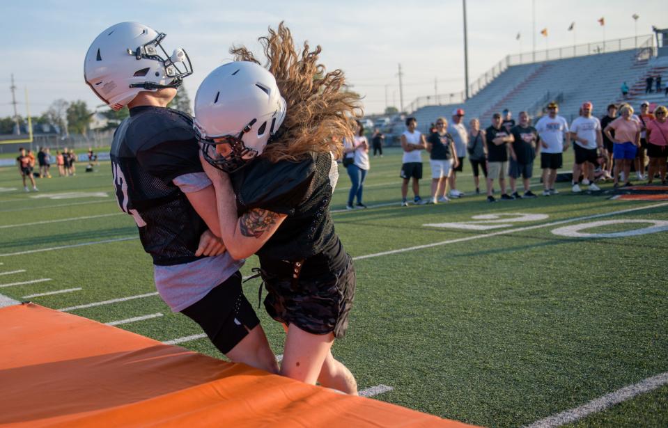 Washington Panthers football mom Amber Hulet puts a hard hit on her son Zane during the annual Mom's Night festivities Thursday, Aug. 10, 2023 at Babcook Field in Washington.