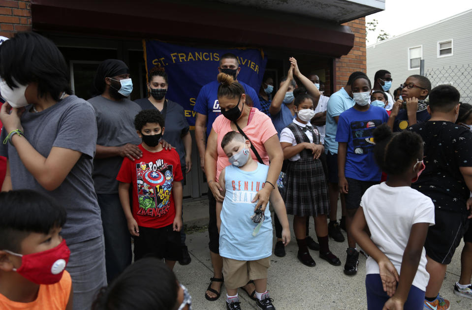 Dozens of students and their family members gather outside St. Francis Xavier School in Newark on Thursday, Aug. 6, 2020, a week after the Archdiocese of Newark announced its permanent closure. (AP Photo/Jessie Wardarski)